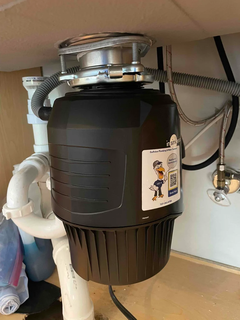 InSinkErator garbage disposal with Gulfview service label beneath a kitchen sink