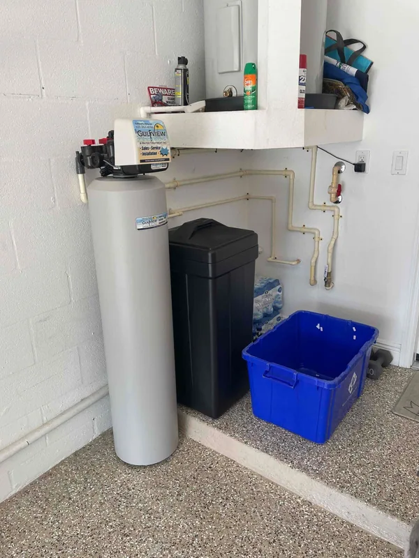Gulfview treatment tank and black brine cabinet below a utility shelf in a garage