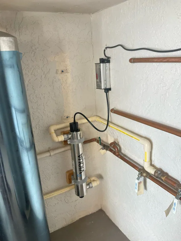 Stainless VIQUA treatment chamber and wall-mounted controller connected to water piping