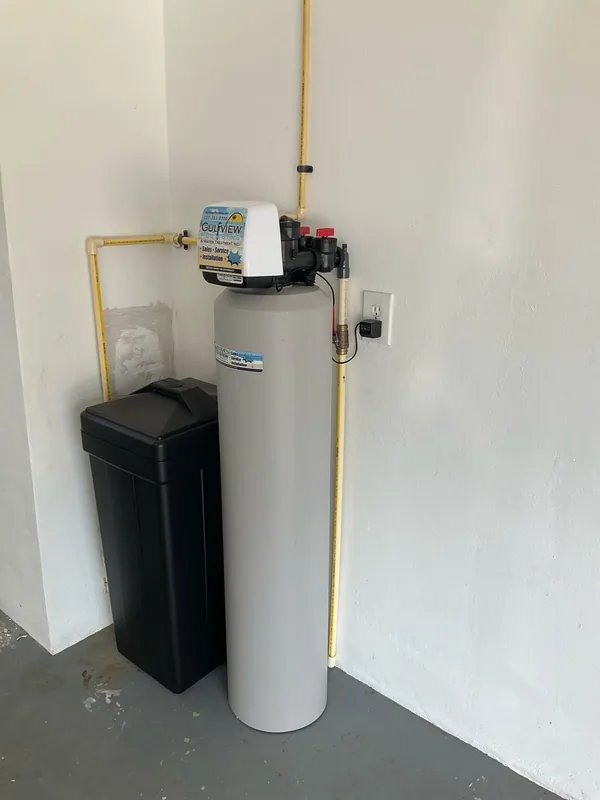 Gulfview water softener and black brine cabinet against a white garage wall