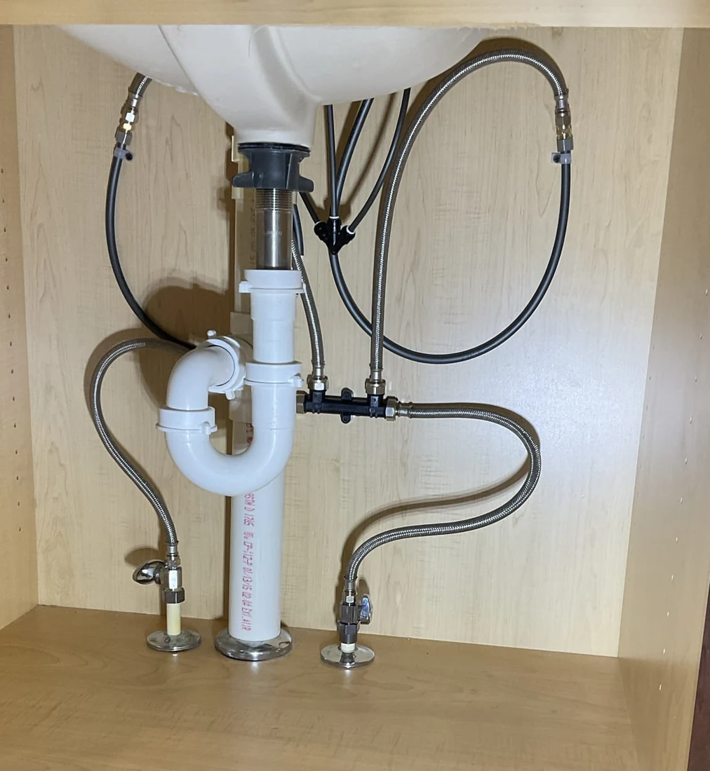 Under-sink supply hoses, crossover valve and drain piping from a Gulfview job