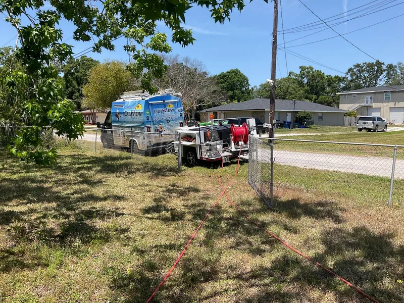 Gulfview service van and trailer-mounted jetting equipment beside a residential yard