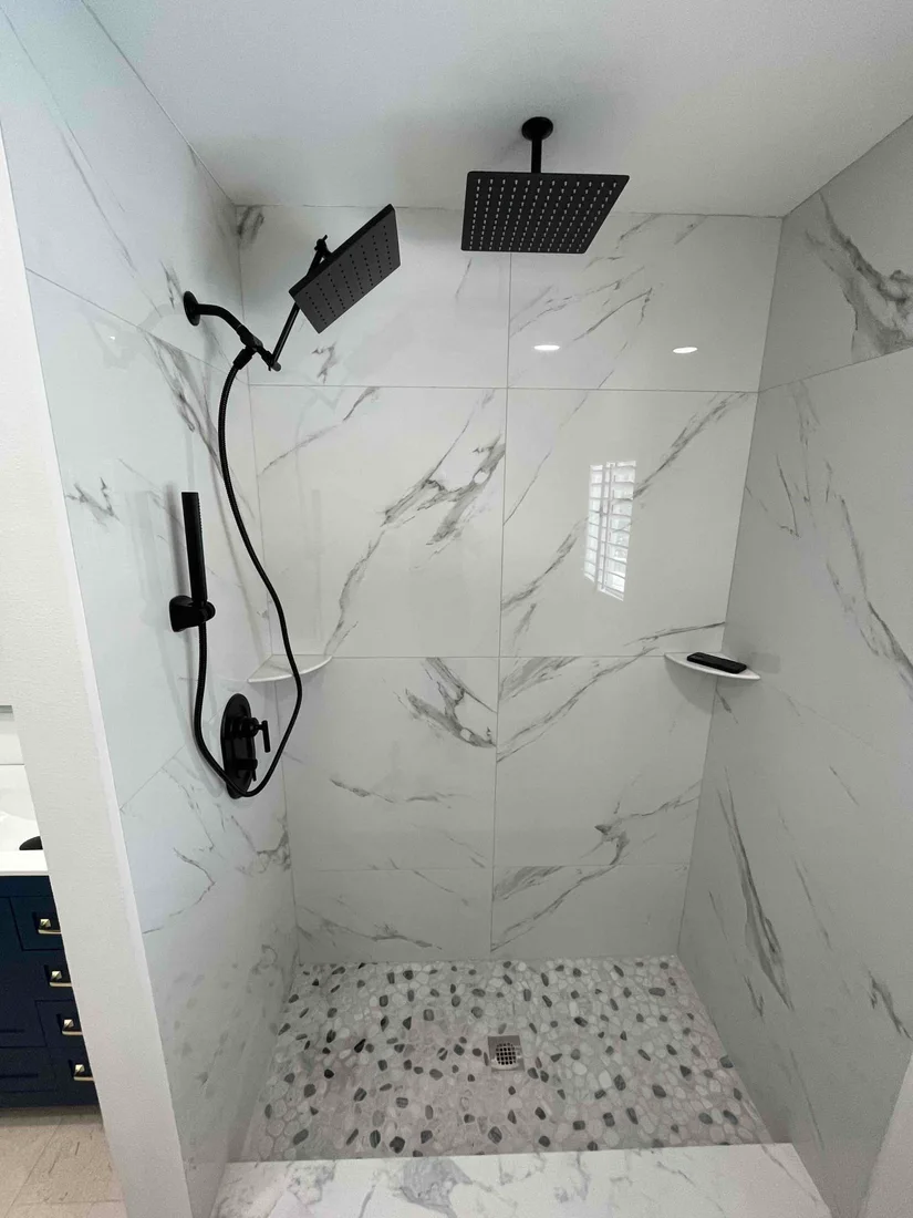 Black shower fixtures with rain head, handheld shower and wall control