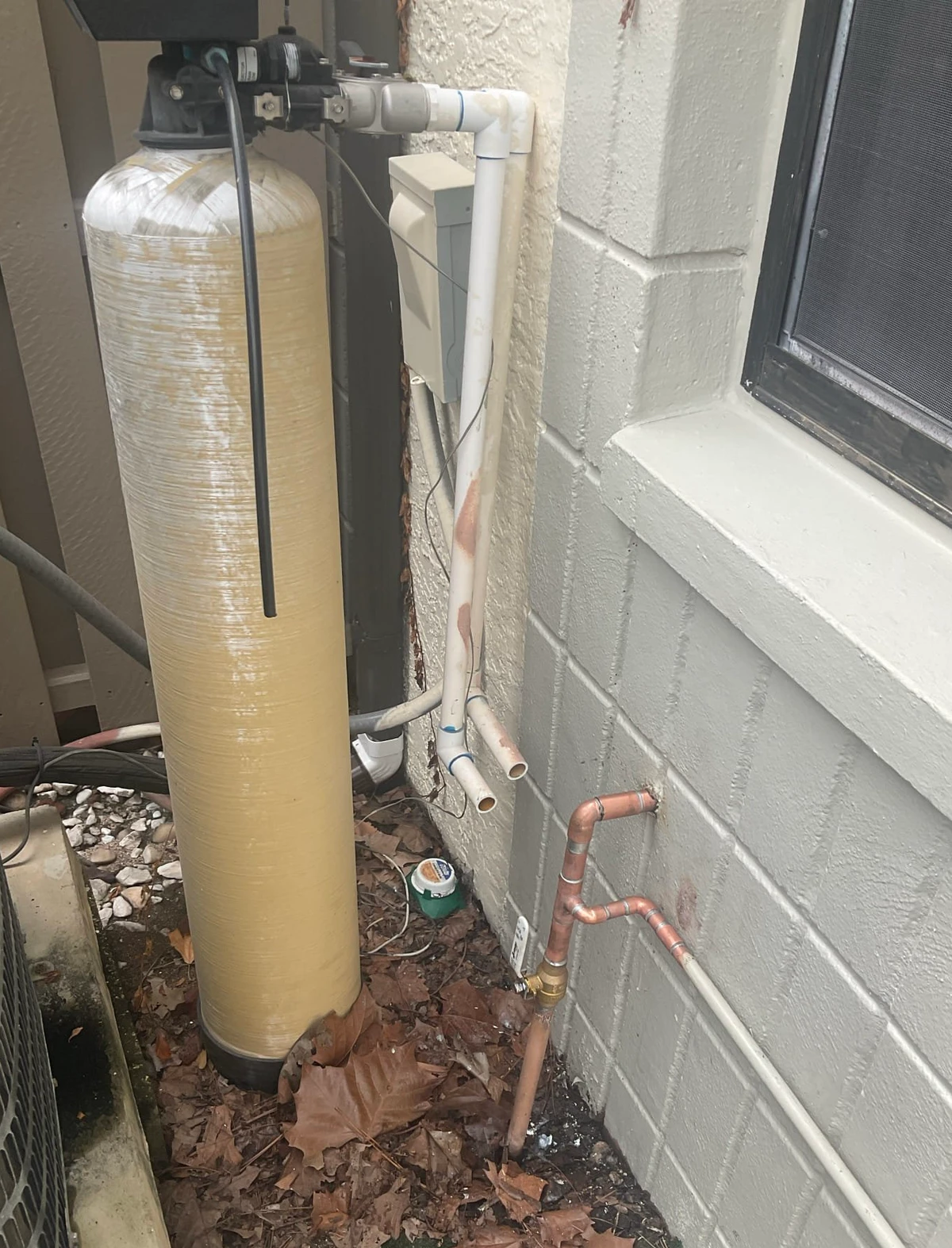 Disconnected water softener still on site beside the replacement shutoff valve and updated copper piping