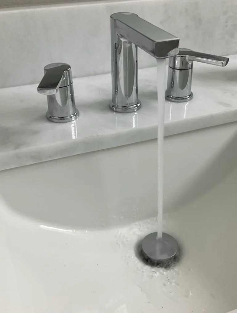 Chrome Moen bathroom faucet running into a white sink at a Gulfview residential job.