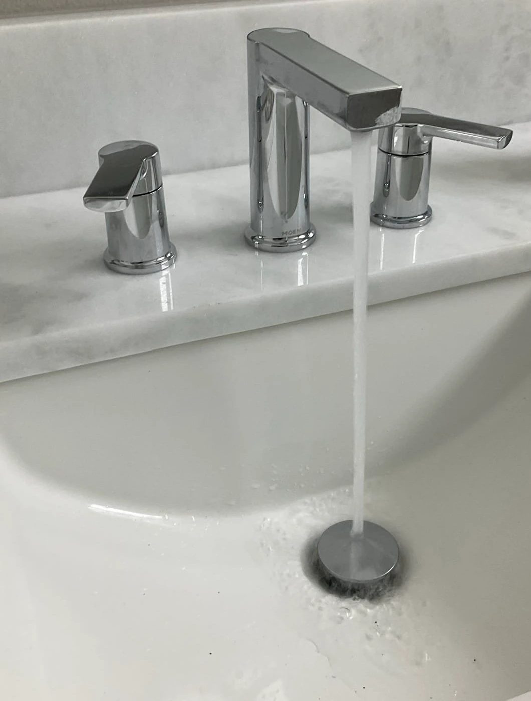 Chrome Moen bathroom faucet running into a white sink at a Gulfview residential job