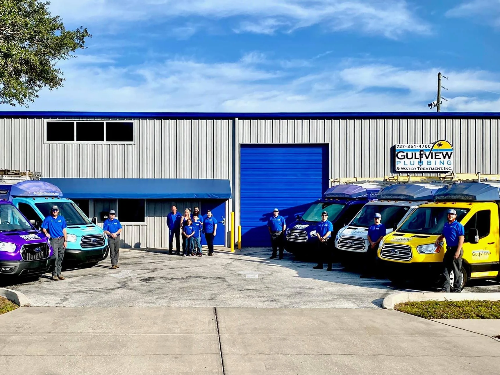 Gulfview team with branded service trucks outside the company building